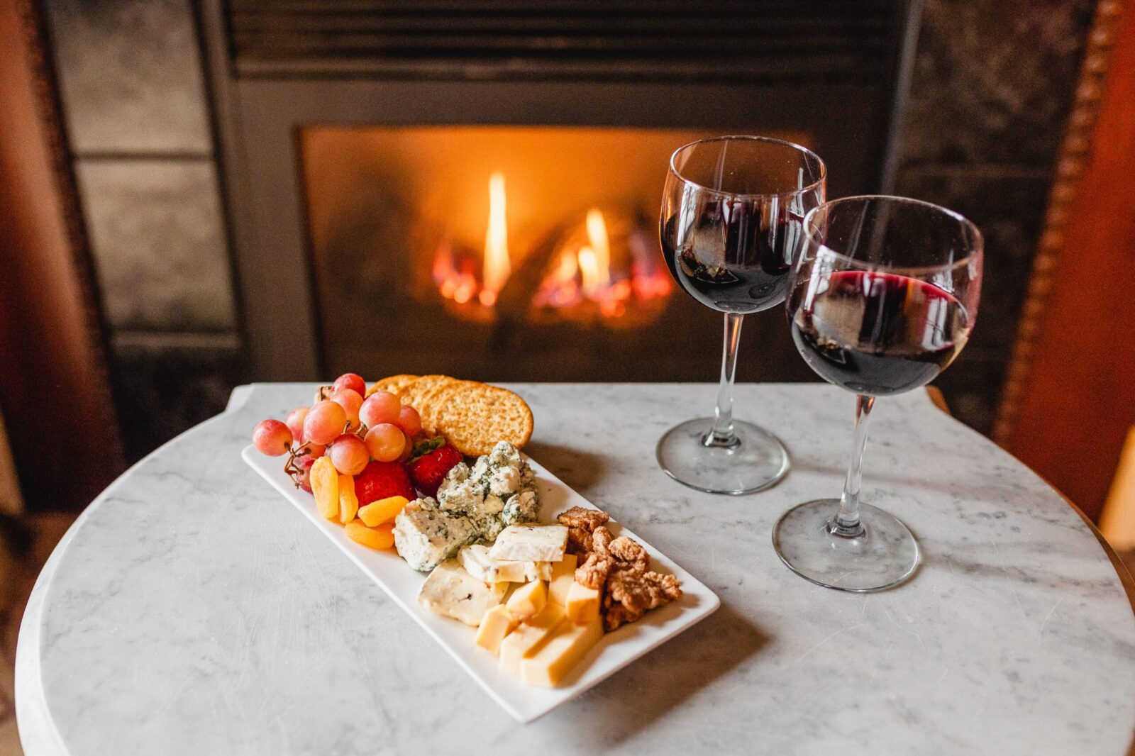 Wine and cheese in front of the fire in a Victorian era suite, perfect for romantic getaways in MN.